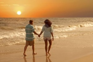 3097466-a-couple-walking-together-on-the-beach-at-sunset